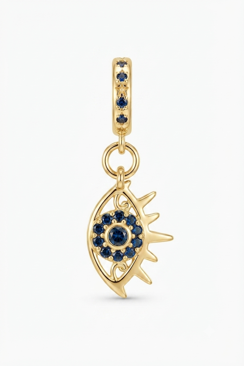 Gold-tone sun eye charm with blue crystals on a white background