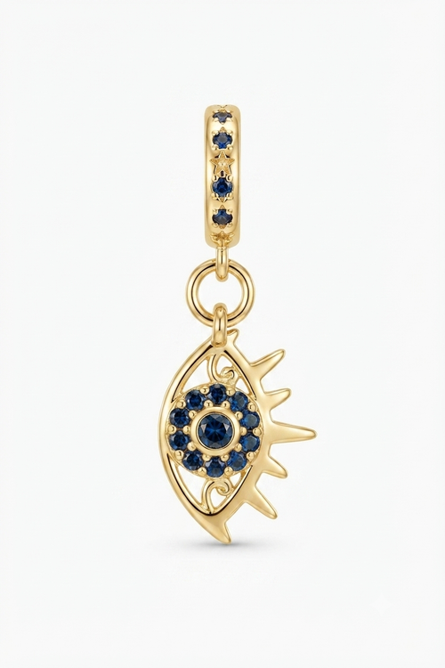 Gold-tone sun eye charm with blue crystals on a white background