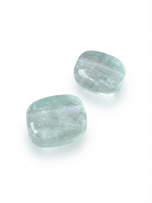 Pale aqua polished crystal nugget beads on a white background