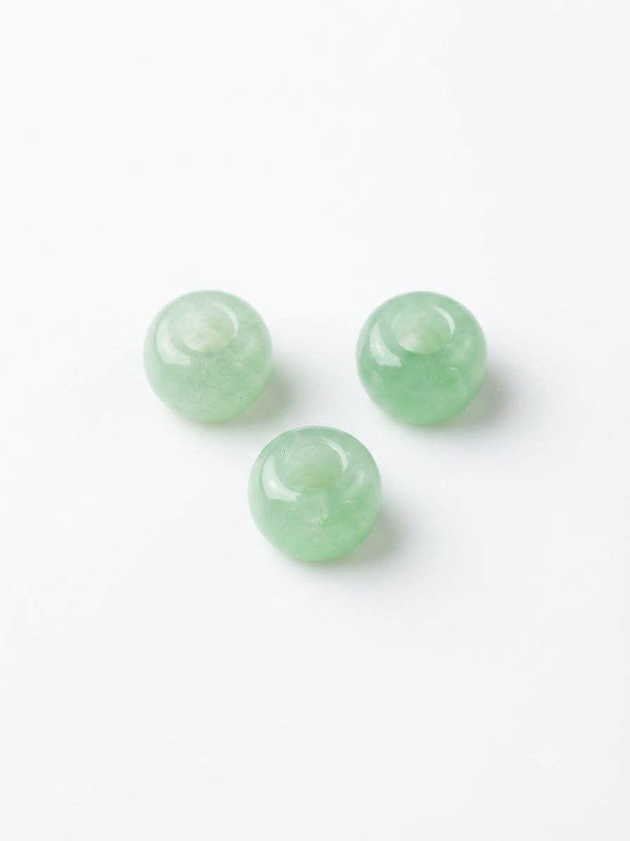 Light green translucent round crystal beads on a white background