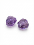 Faceted purple amethyst nugget beads on a white background
