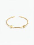 Waterproof gold-plated open charm bangle with two silicone-lined stopper beads on a white background